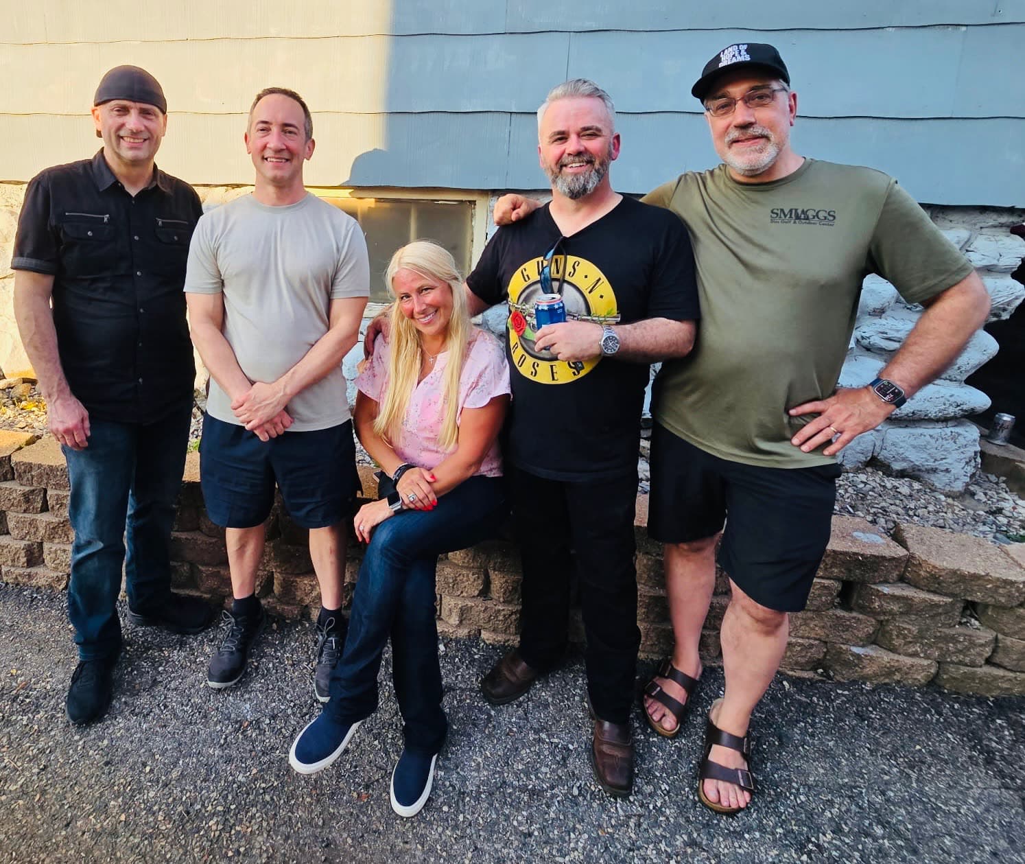 The five members of Out of the House Band posing together outdoors
