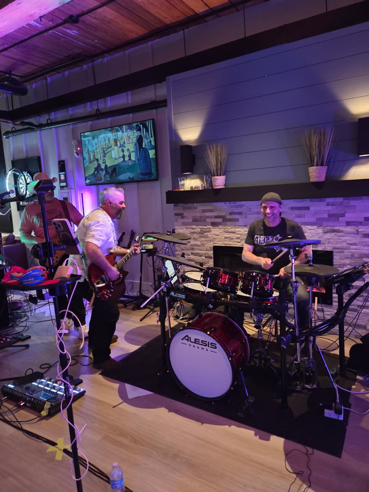 Guitarist and drummer sharing a candid laugh mid-performance