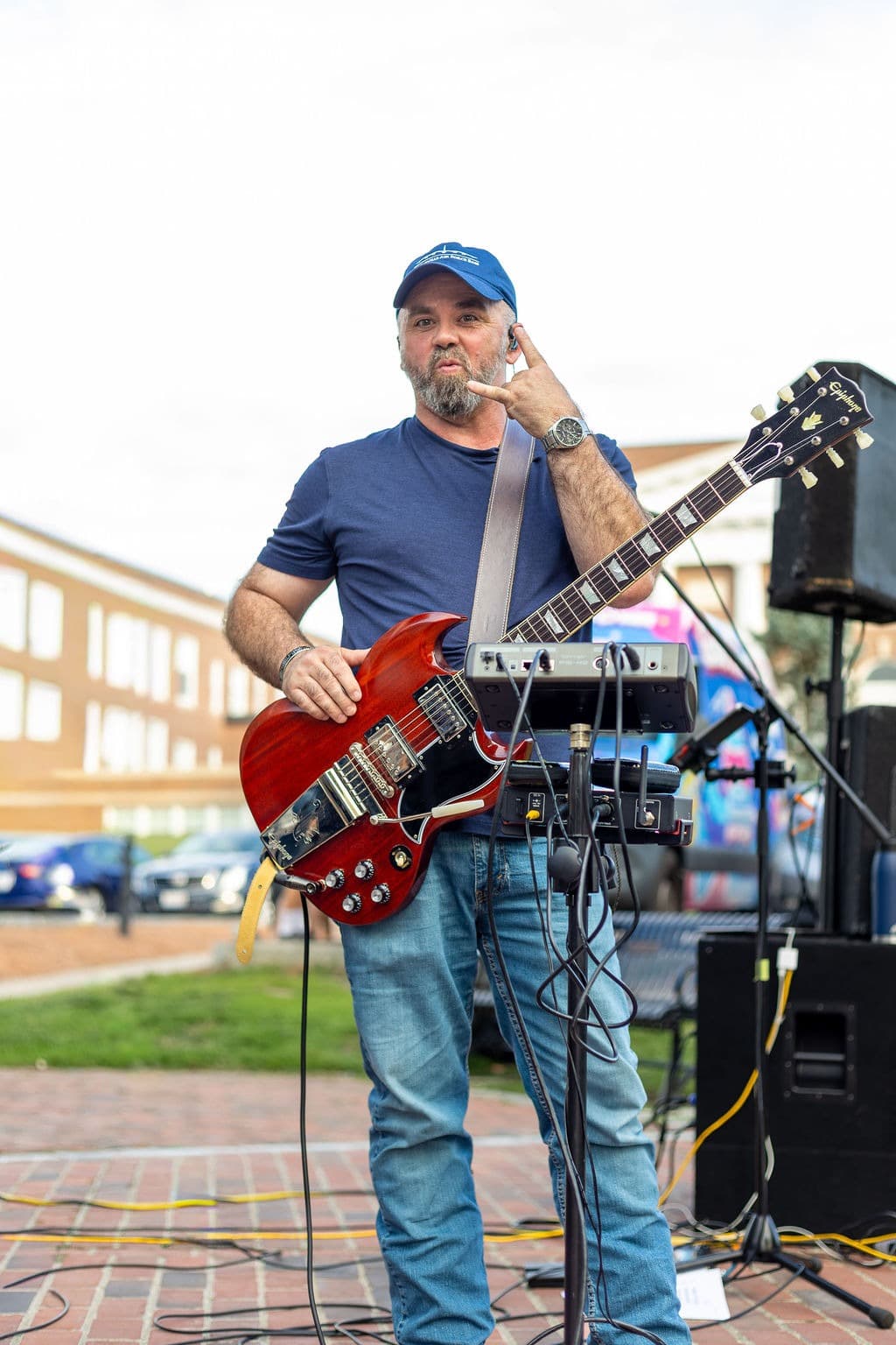 Guitarist throwing a rock-on hand sign between songs
