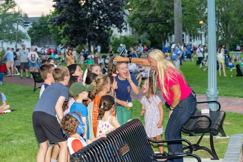 Lead singer laughing and cheering with a group of kids in the audience