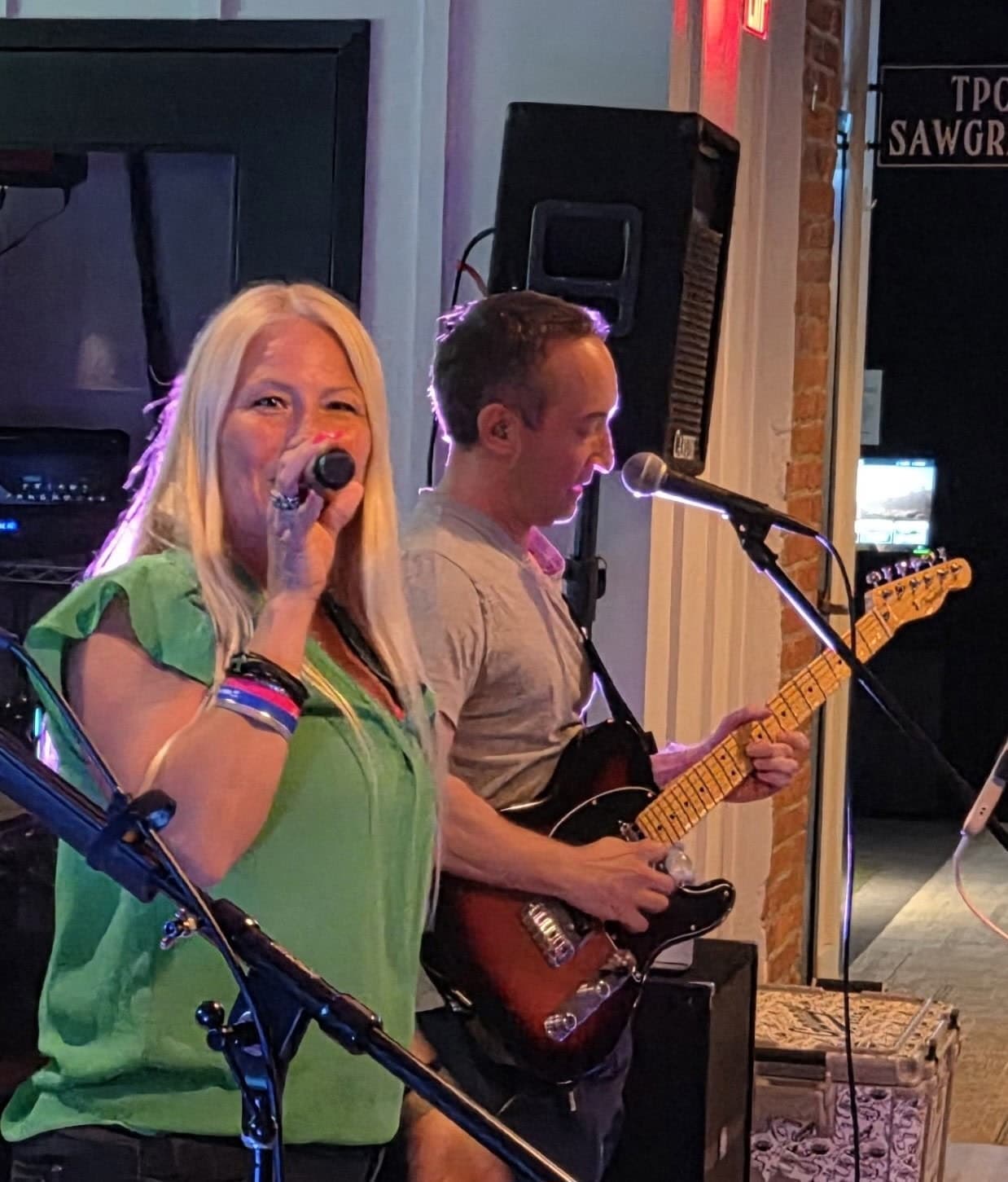 Lead singer and guitarist performing together in a close-up shot