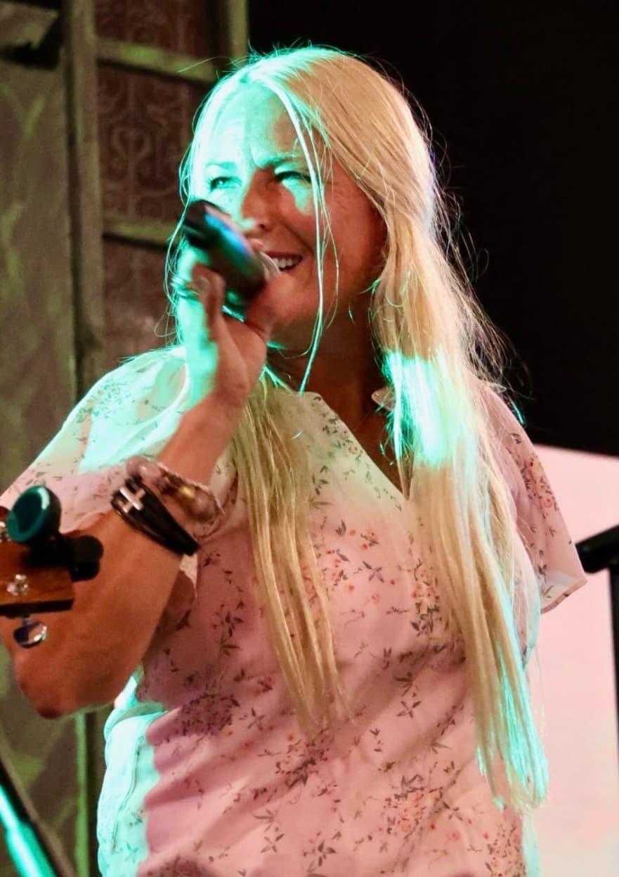 Close-up of the lead singer performing under teal stage lighting
