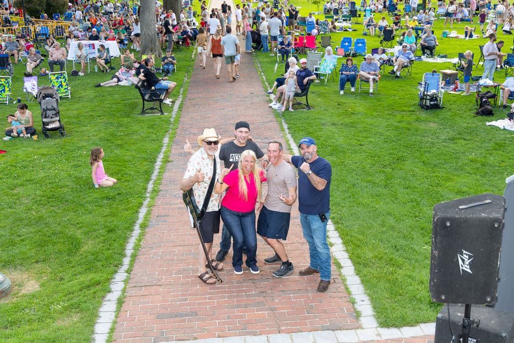 Aerial view of a packed town common crowd of families in lawn chairs watching the band perform